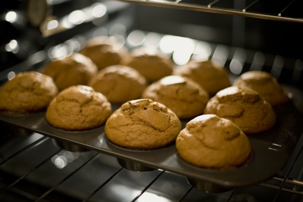 A pan of fresh-baked pumpkin muffins coming straight out of the oven.