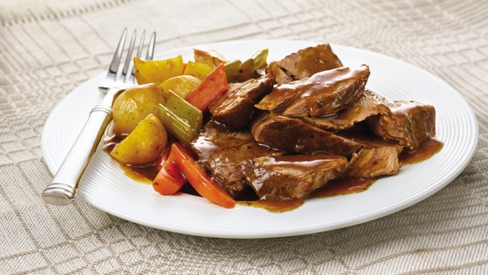 A delicious savory slow-cooked pot roast on a dinner plate.