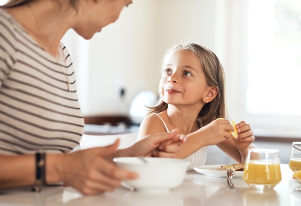 Shot of an adorable little girl having breakfast with her mother at home