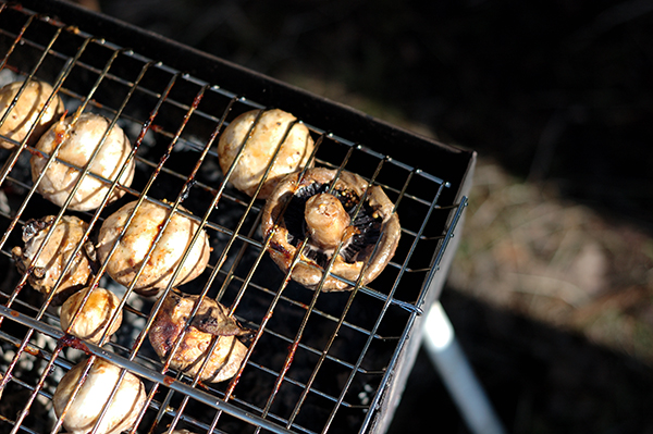 Mushrooms champignons being cooked on the grill 