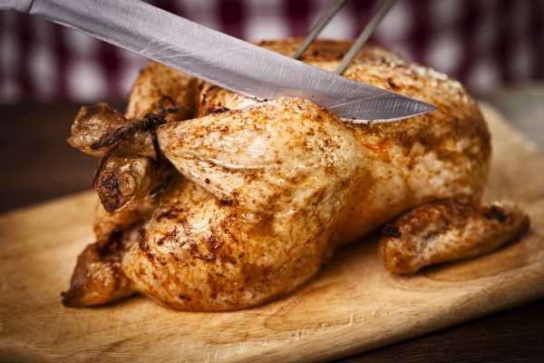 Someone carving a delicious roast chicken