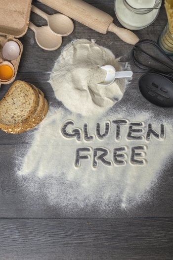 The words "gluten free" written in gluten free flour, surrounded by baking utensils. 