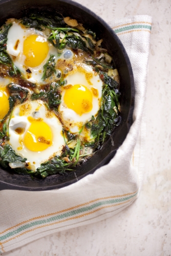 Delicious vegetarian breakfast: baked eggs and kale drizzled with spiced brown butter.