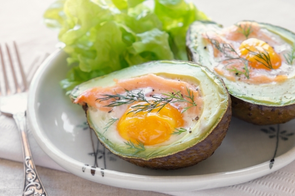 A plate with baked smoked salmon and egg in avocado