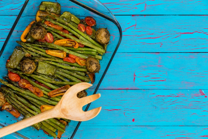 Roasted Vegetables in a glass pan on a blue table