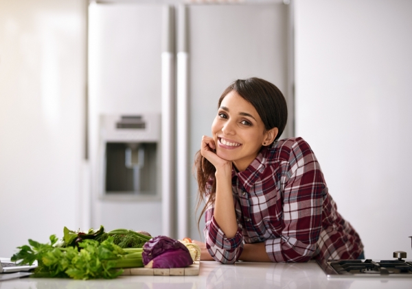 Cropped shot of a young Hispanic woman cooking in the kitchen at home