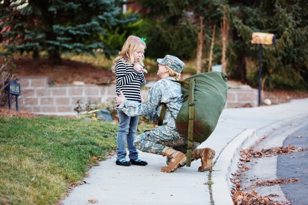 A female soldier saying goodbye to her daughter.