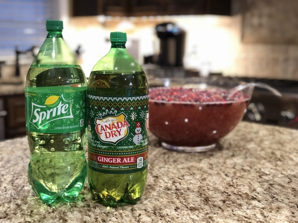 Two litter bottles of Canada Dry Ginger Ale and Sprite with the Christmas punch in the background.
